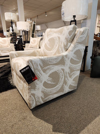 Beige 2627 Swivel Accent Chair by Decor-rest with white swirls and sloped arms displayed in a furniture store with tag.