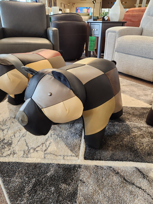 Reiner's Originals Reiner's Leather Animal Ottomans--Bear sits on a patterned rug in a stylish furniture showroom.