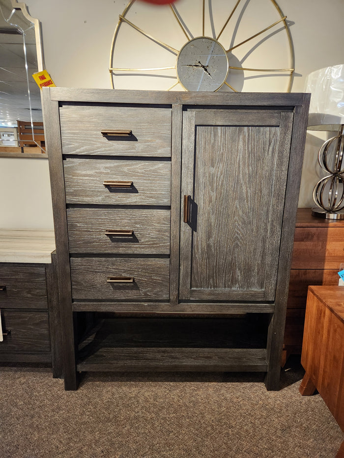 Magnussen B5990 Plum Creek Door Chest with Ravenwood Black finish and bronze hardware on a carpeted floor.