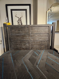 The Magnussen Plum Creek B5990 Queen Storage Bed with burnished bronze hardware, geometric comforter, and deer photo.
