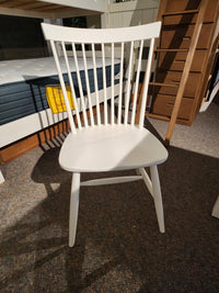 The 834 Laptop Desk Chair by Ben & Erin Napier for Vaughan Bassett sits by a bed and oak veneers furniture on a carpet.