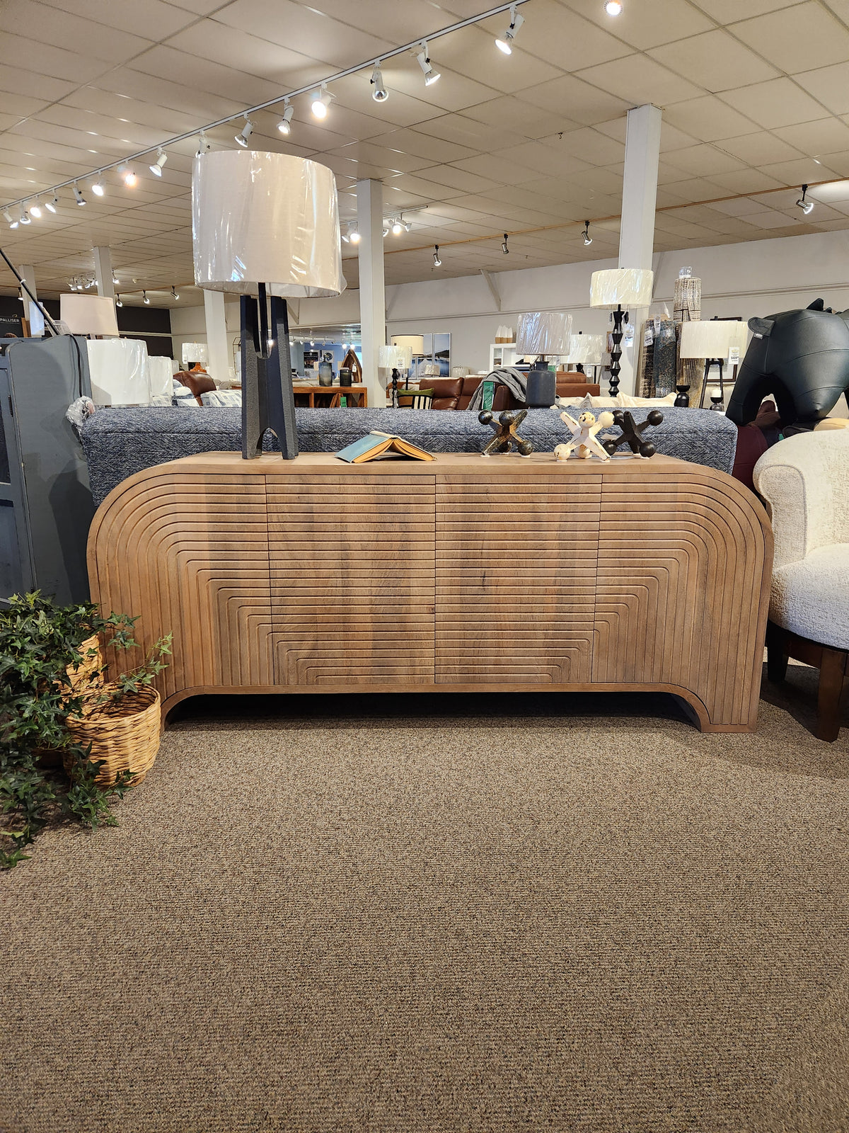 The Mercana 70838 Sorina Reverse Fluted Sideboard in solid mango wood is showcased with lamps and decor.