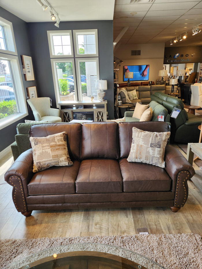 The Best Field & Stream Noble Sofa features top-grain leather and brass tacks, styled with patterned pillows for a modern lodge look.