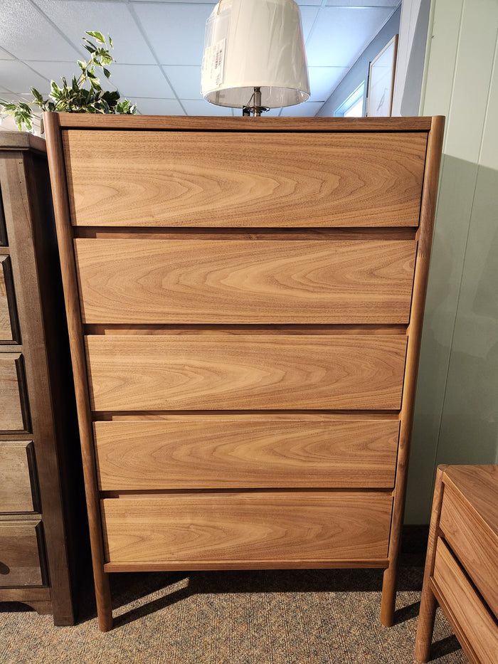 The Palliser EQ3 Monarch Chest, topped with a lamp and plant, stands in a carpeted room.