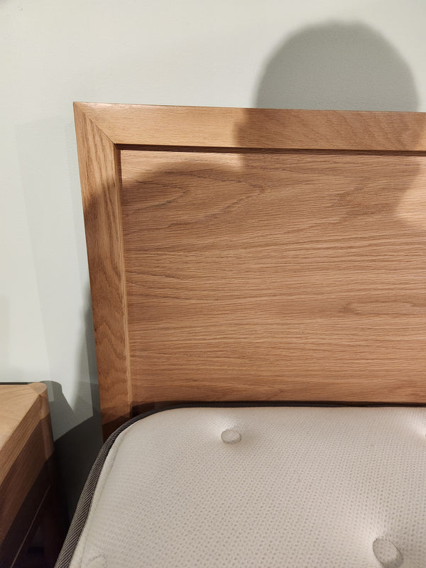 A Palliser EQ3 Marcel Queen Bedframe with a wood veneer headboard and white mattress is partly visible in front.