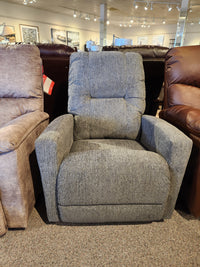 The La-z-boy 767 Casey Power Rocker Recliner with gray upholstery is displayed between two chairs in a showroom.