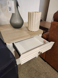 The Magnussen B6310- Echo Isles End Table displays a gray vase and a beige textured vase on its open drawer.