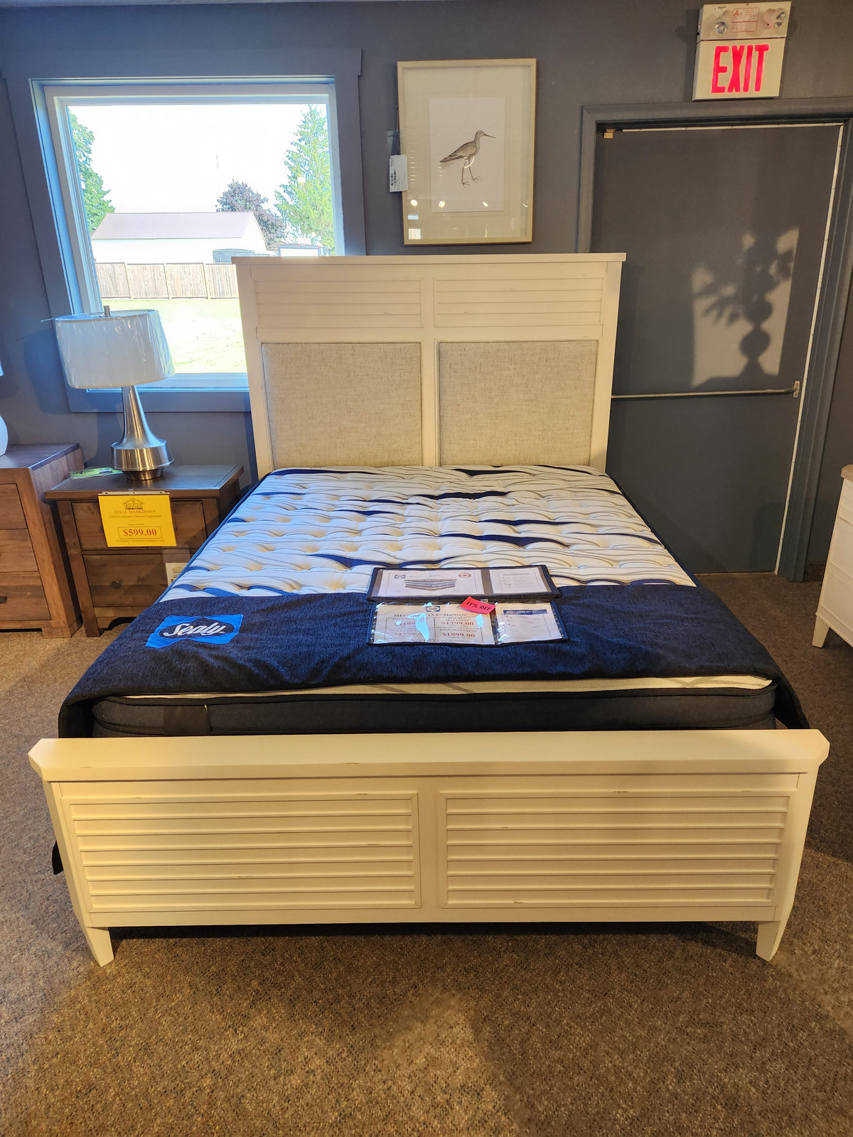 The Magnussen B6310 - Echo Isles Bed is a white wooden frame with transitional casual style for showroom display.