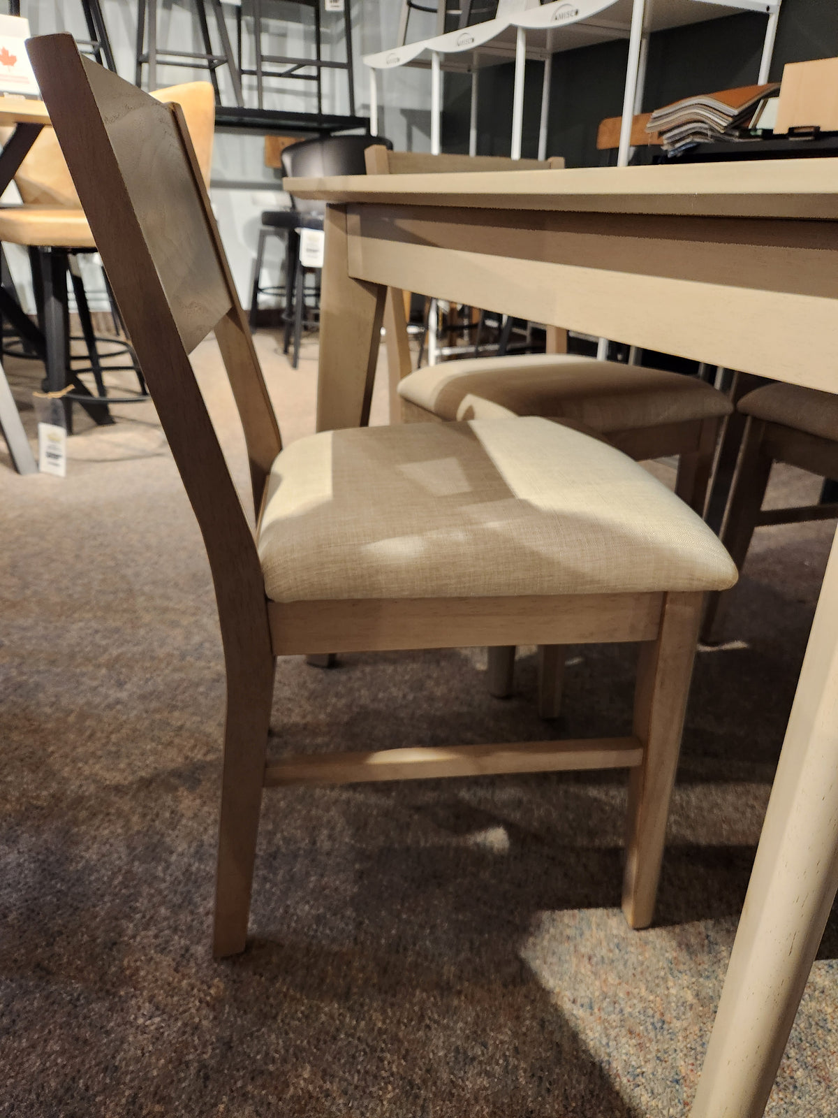The Donald Choi York Dining Set showcases a cushioned chair and matching table in a stylish showroom.