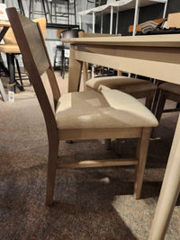 The Donald Choi York Dining Set showcases a cushioned chair and matching table in a stylish showroom.