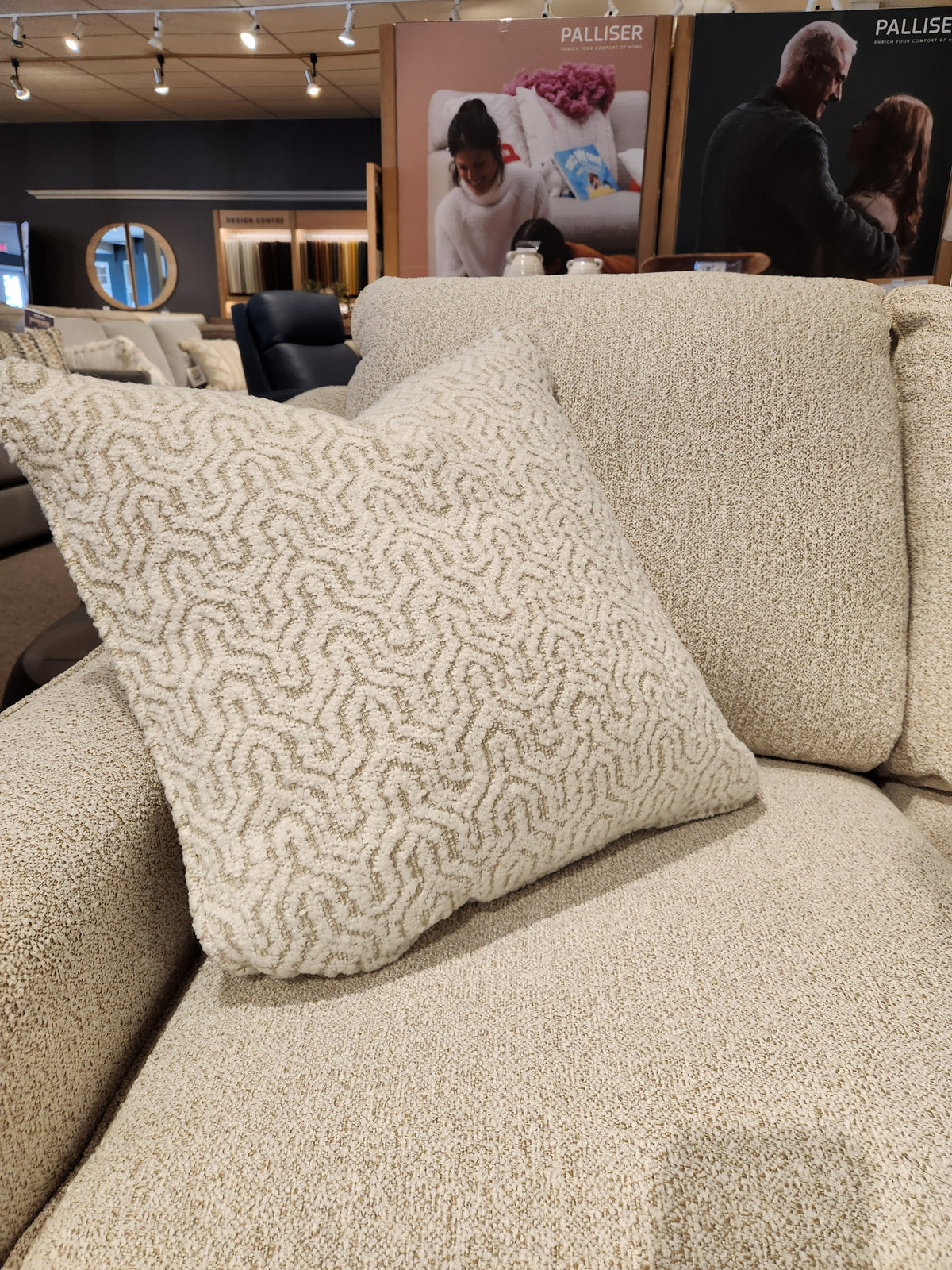 A beige textured throw pillow accents the Decor-rest 2981 Loveseat with box seat cushions in a showroom.