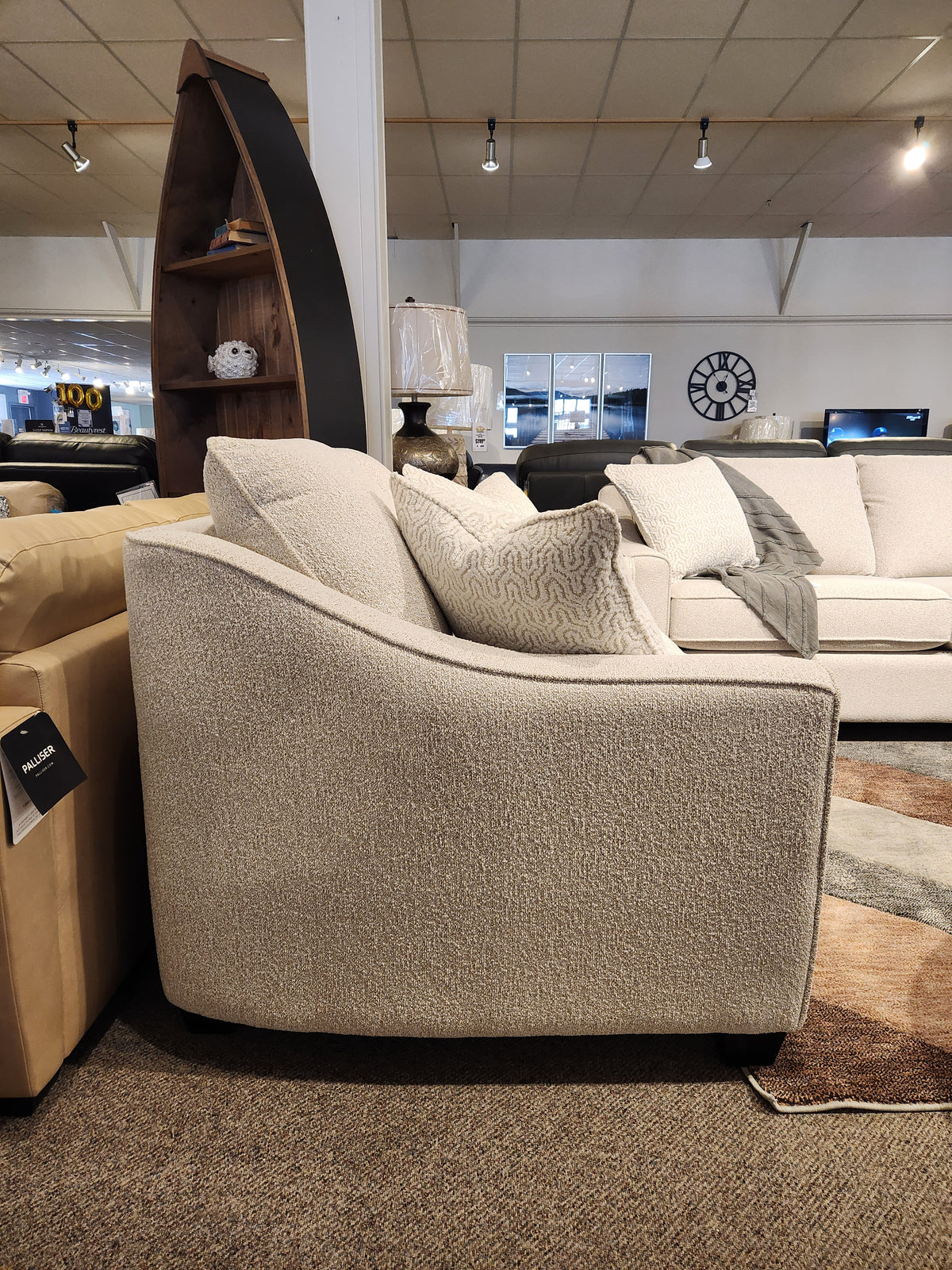 A beige armchair sits in a showroom beside the matching Decor-rest 2981 Loveseat with textured fabric and box seat cushions.