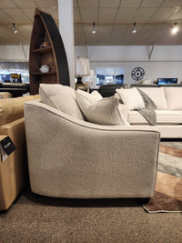 A beige armchair sits in a showroom beside the matching Decor-rest 2981 Loveseat with textured fabric and box seat cushions.