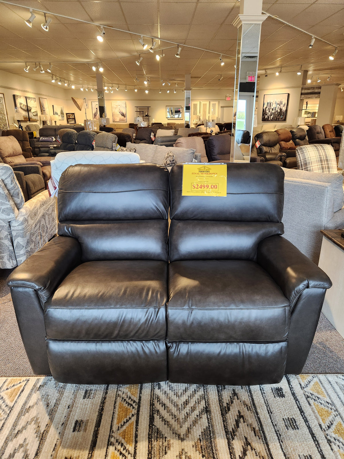 A La-z-boy 769-U48 Ava Power Loveseat in black leather reclines, priced at $2499 in the showroom.