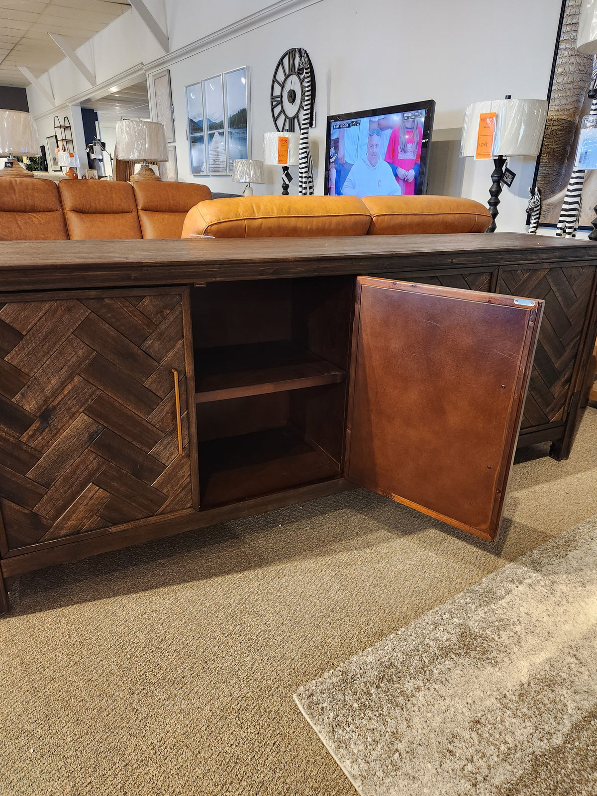 The Jofran Gramercy 4 Door Accent Cabinet features dark wood, chevron inlay doors, open to reveal shelves and decor above.