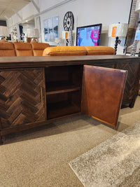 The Jofran Gramercy 4 Door Accent Cabinet features dark wood, chevron inlay doors, open to reveal shelves and decor above.