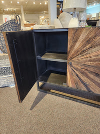 Jofran’s 1928 Astral Plains 2 Door Cabinet features textured fronts, open shelving, and is displayed in a furniture showroom.