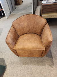 A 752 Swivel Chair by Leather Craft in brown leather, with a curved back, set in a carpeted room surrounded by furniture.