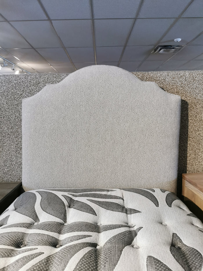 830 Upholstered Twin Bed by Vaughan Bassett in Tide & Timber store; headboard speckled, mattress with leaf design.