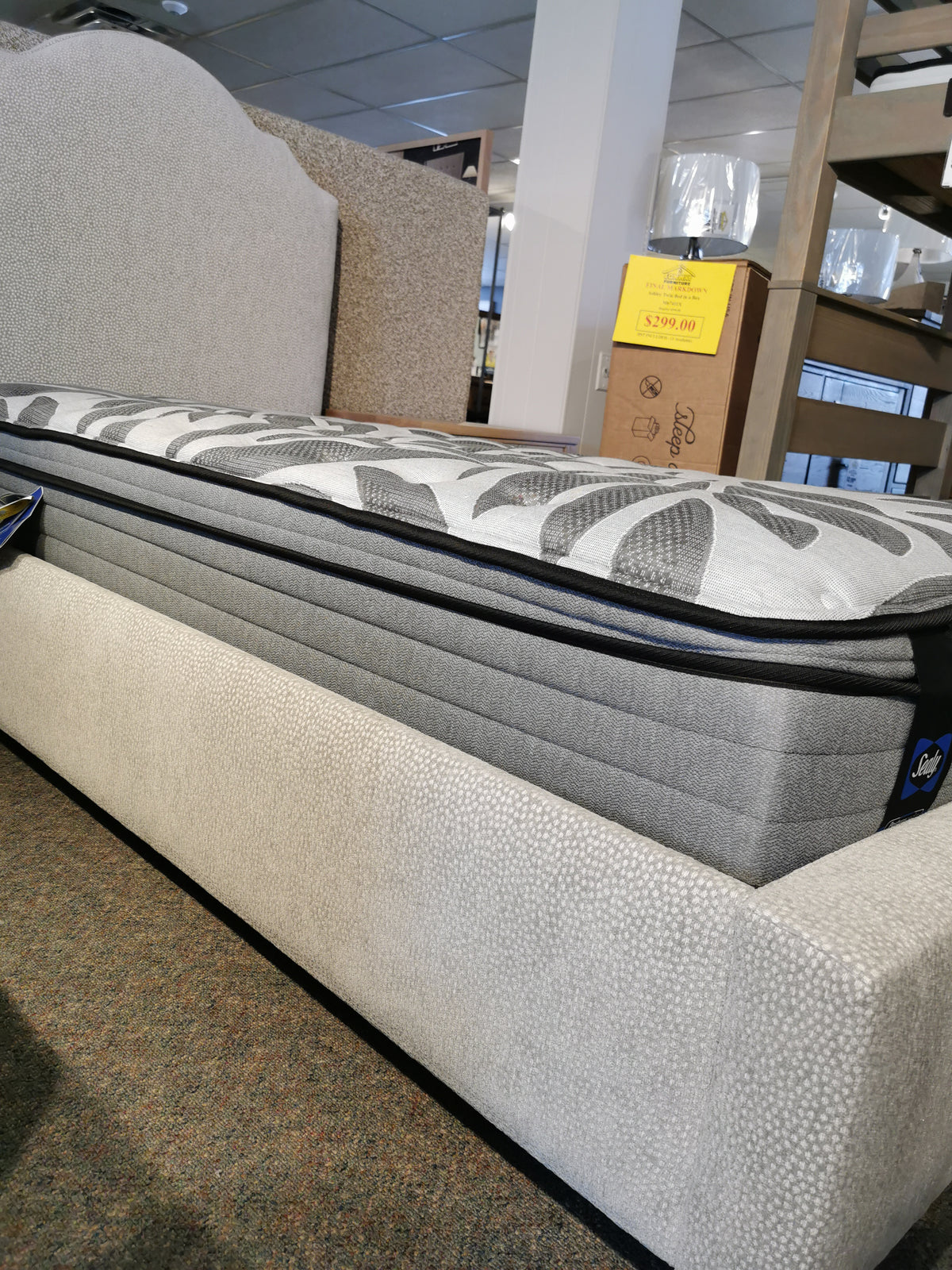Vaughan Bassett's 830 Upholstered Tide & Timber Twin Bed with price tag in view on a store display.