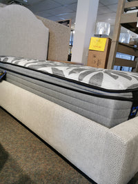 Vaughan Bassett's 830 Upholstered Tide & Timber Twin Bed with price tag in view on a store display.