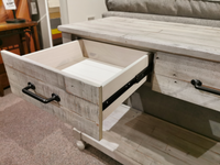A solid pine wood drawer with a black handle is partially open in the Ashley Shawnalore Sofa Table.