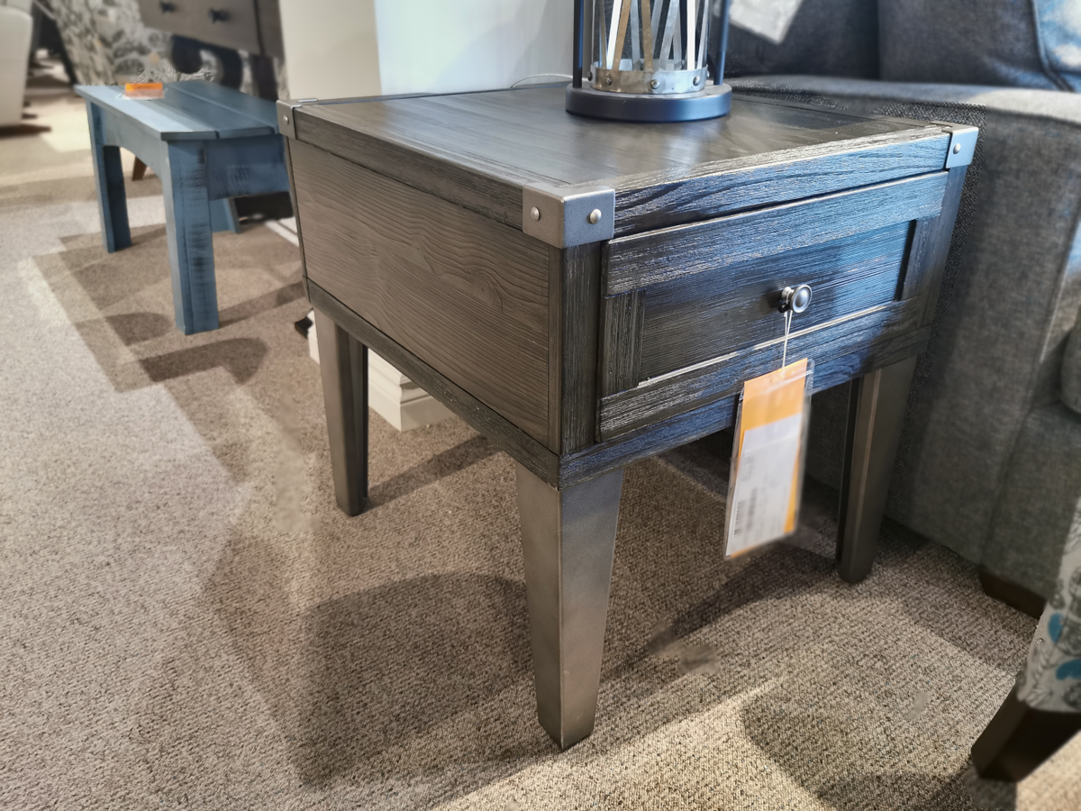 The Tadoe End Table by Ashley is a rustic-industrial table in weather-washed pine with a drawer and USB ports.