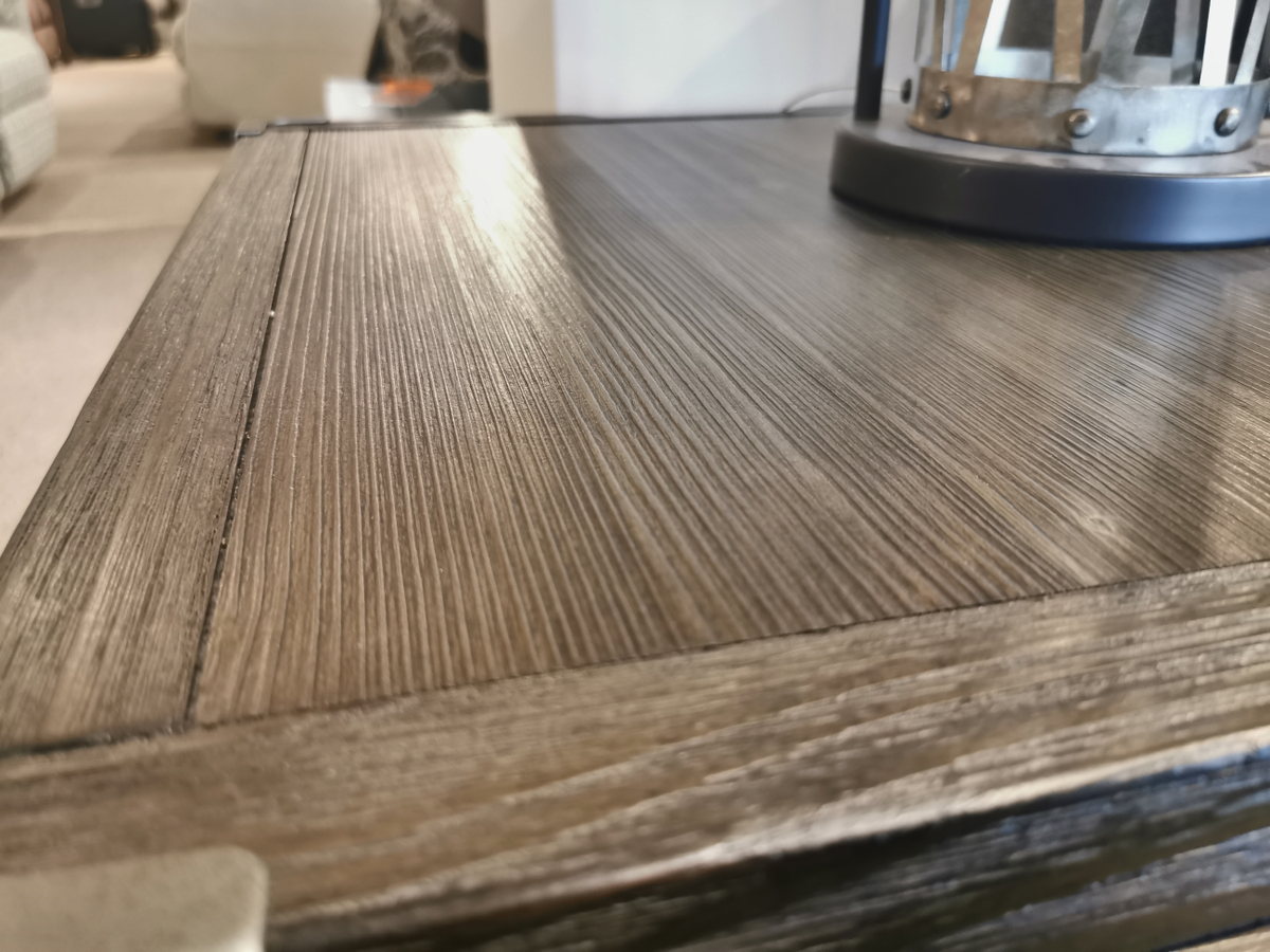 Close-up of the Ashley Tadoe End Table featuring weather-washed pine and a metal lantern on the right corner.