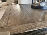 Close-up of the Ashley Tadoe End Table featuring weather-washed pine and a metal lantern on the right corner.