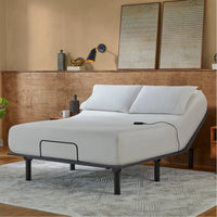 The Beauty-Rest Bronze Adjustable Base features white bedding, a sturdy frame, and a wire remote in a modern bedroom.