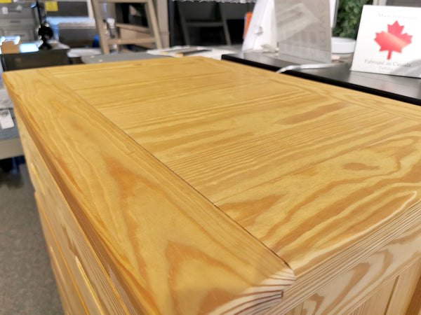Close-up of A7015 5 Drawer Chest by Crate, highlighting wood grain beside solid drawer box displays in showroom.