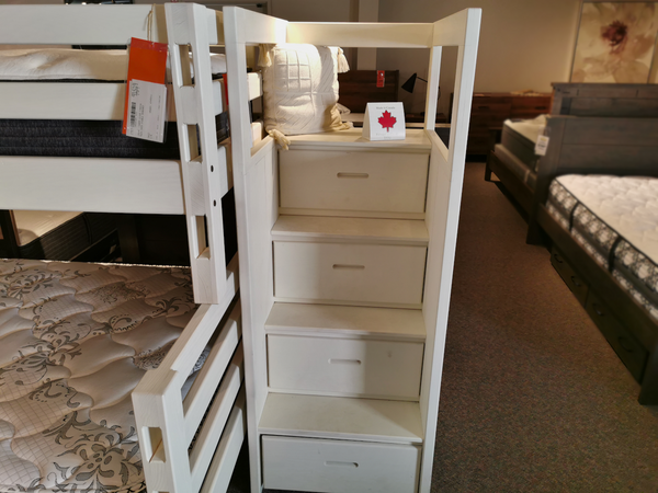 The Crate C4900 Bunk Bed Staircase with solid wood drawers is on display; mattresses are nearby in the store.