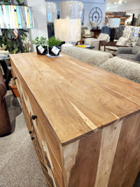 A Crestview Collection Sierra Nevada Cabinet is displayed in a furniture showroom.