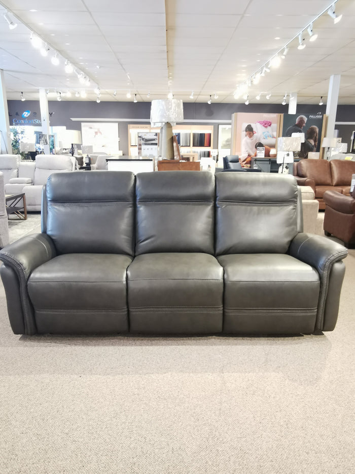 The Cascade Power Sofa by Aurora Furniture is a dark gray leather design with power headrest in the showroom.