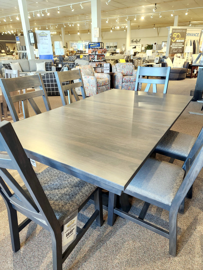 A Handstone BE4260 Belmont Dining Package with six side chairs is on display in a furniture showroom.