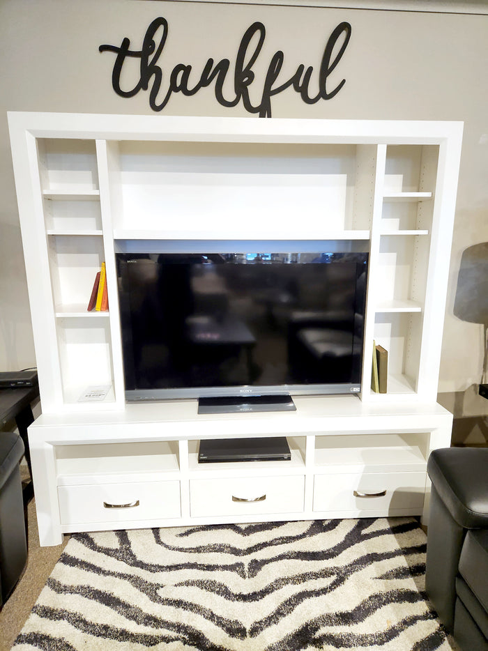 A flat-screen TV on the Handstone Contempo 72" Entertainment Unit with Hutch, "thankful" sign above this modern setup.
