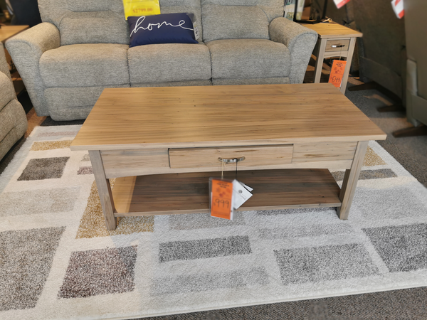 Handstone N-gg48 Glengarry Coffee Table with drawer and shelf, shown on a patterned rug in a modern showroom.