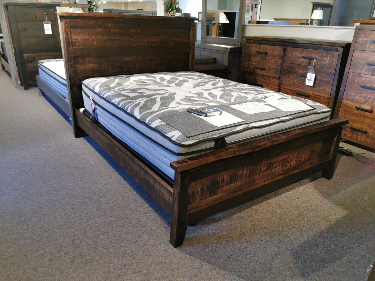 The Handstone PE-QL Pemberton Q Bed with sculpted curves and mattress is on display in the furniture store.