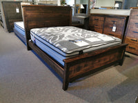 The Handstone PE-QL Pemberton Q Bed with sculpted curves and mattress is on display in the furniture store.