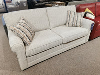 Simmon 930-62 Double Sofa Bed by Simmons Upholstery with two patterned pillows, shown beside a red couch in showroom.