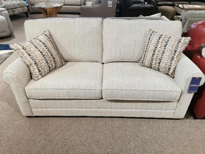 The Simmon 930-62 Double Sofa Bed by Simmons Upholstery with patterned pillows is on display in a furniture showroom.