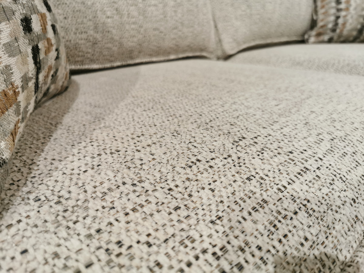 Close-up of a textured beige Simmons Upholstery Simmon 930-62 Double Sofa Bed with two patterned cushions in back.