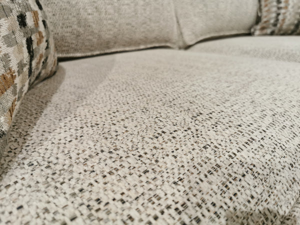Close-up of a textured beige Simmons Upholstery Simmon 930-62 Double Sofa Bed with two patterned cushions in back.