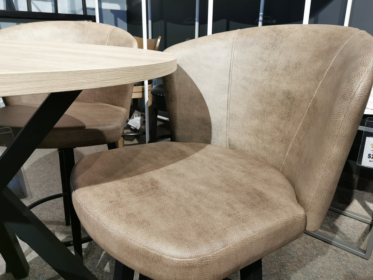 A beige upholstered chair with texture sits by a 39" Amisco laminate round table in a carpeted room.