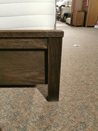 Close-up of the 11 Fundamental Panel Double Bed by Vaughan Bassett on a carpeted floor in a store.