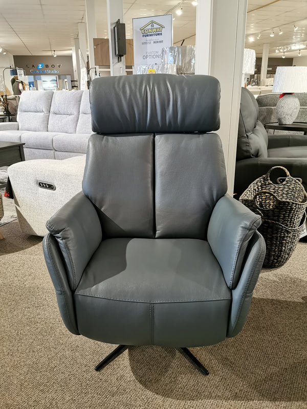 The Argo Power Recliner by Ambiente Chairs in modern gray leather sits on a carpeted showroom floor.