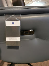 Close-up of the Argo Power Recliner by Ambiente Chairs, in gray Italian leather with tag and side control buttons.