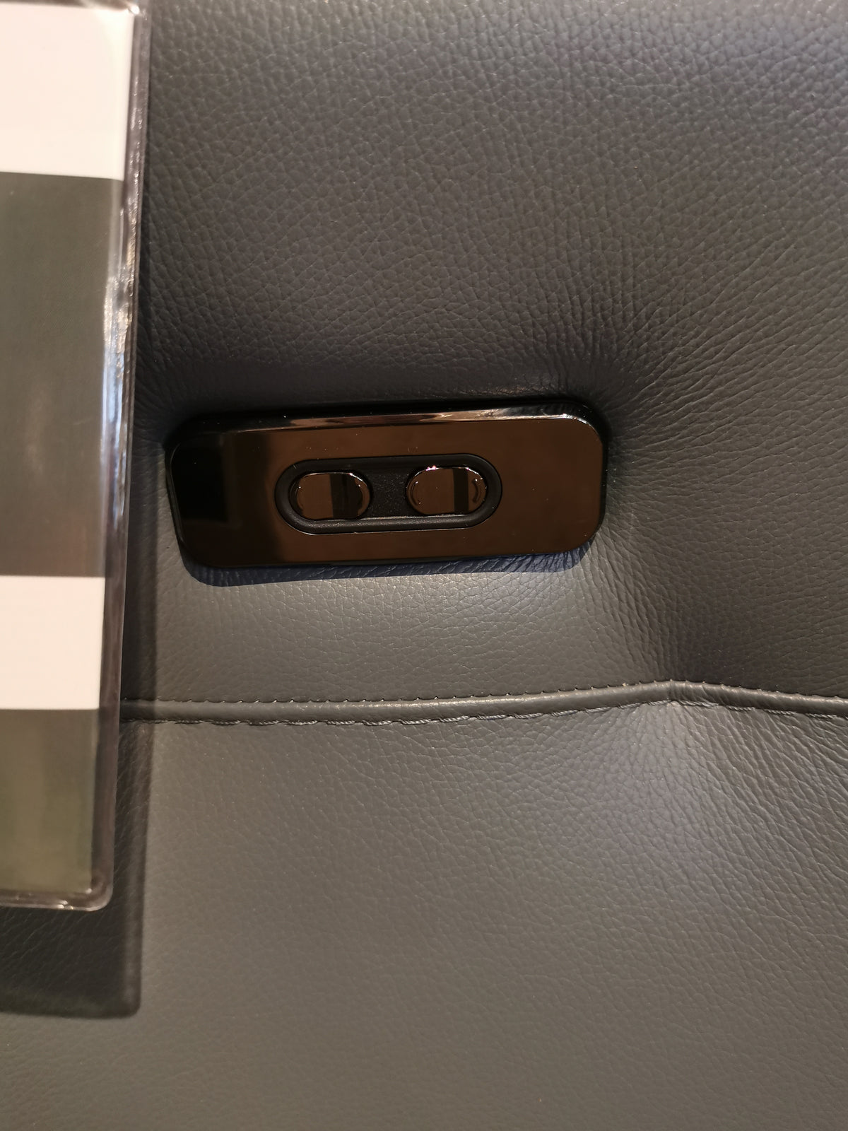 Close-up of two black buttons on gray Italian leather upholstery of the Argo Power Recliner by Ambiente Chairs.