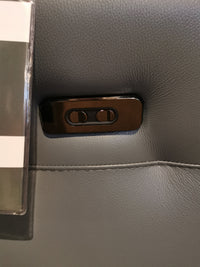 Close-up of two black buttons on gray Italian leather upholstery of the Argo Power Recliner by Ambiente Chairs.