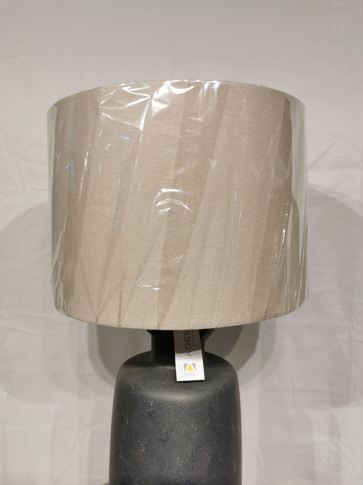 The Adesso Lamp Skylar Table Lamp features a beige shade on a black base, ideal for modern industrial spaces.